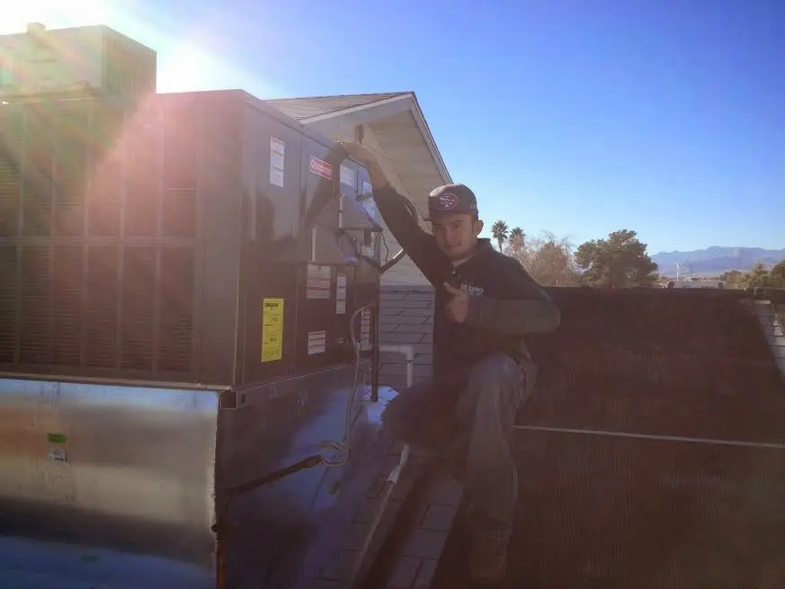 HVAC technician performing HVAC Inspection on a rooftop unit in Belen